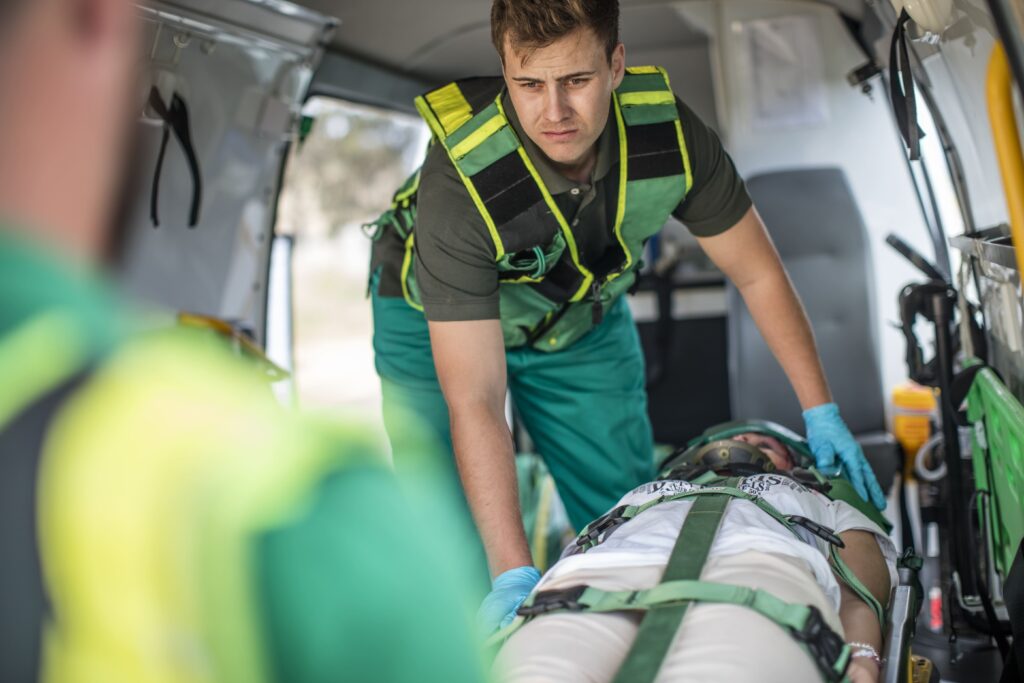 A patient being moved into an ambulance by a medical team to be transferred to a different location.